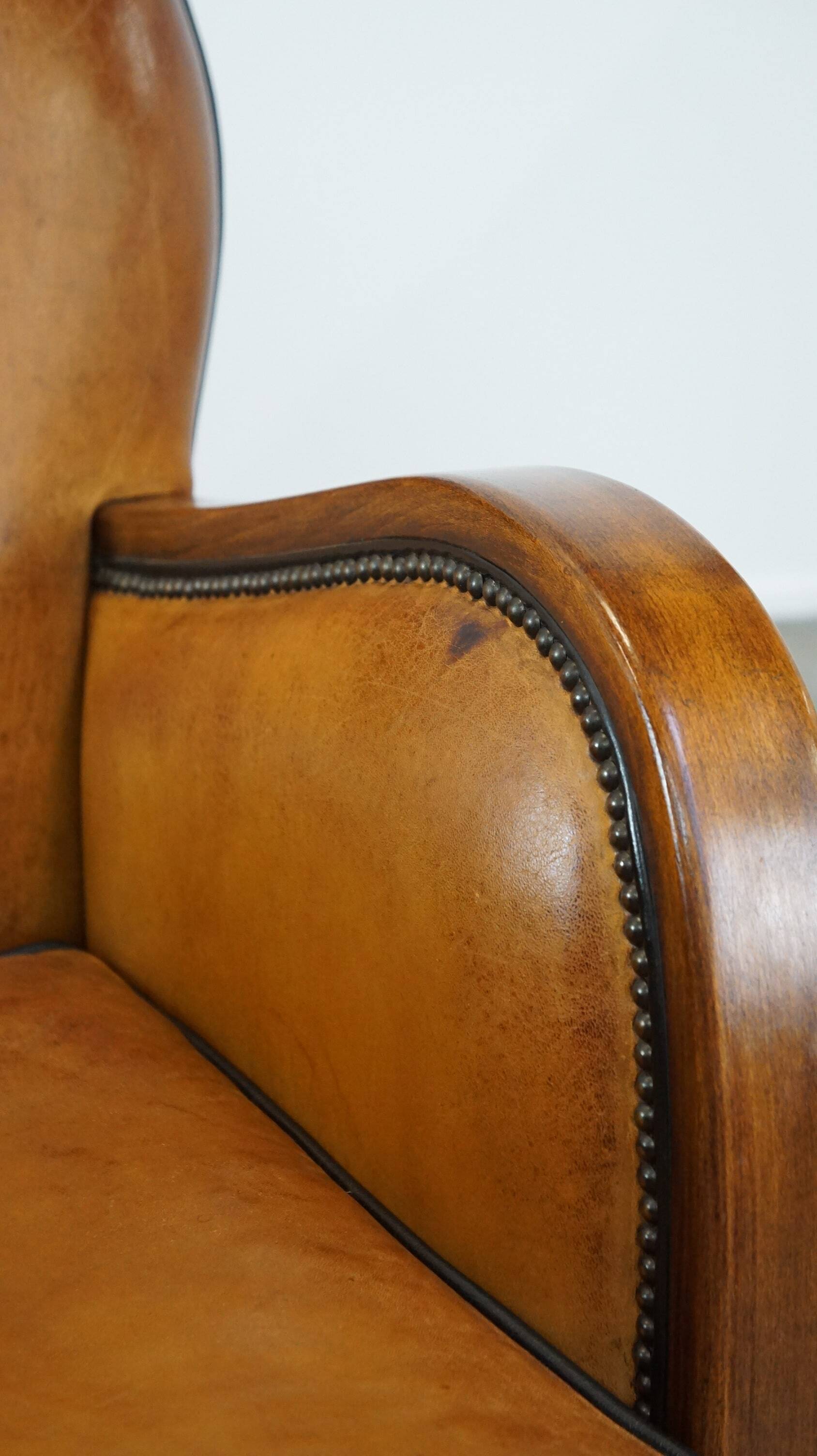Unique, luxurious sheepskin armchair combined with wood and finished with decorative nails