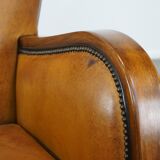 Unique, luxurious sheepskin armchair combined with wood and finished with decorative nails