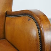 Unique, luxurious sheepskin armchair combined with wood and finished with decorative nails