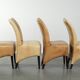 Ensemble de quatre chaises de salle à manger en cuir de vache avec un siège confortable et un dossier haut.
