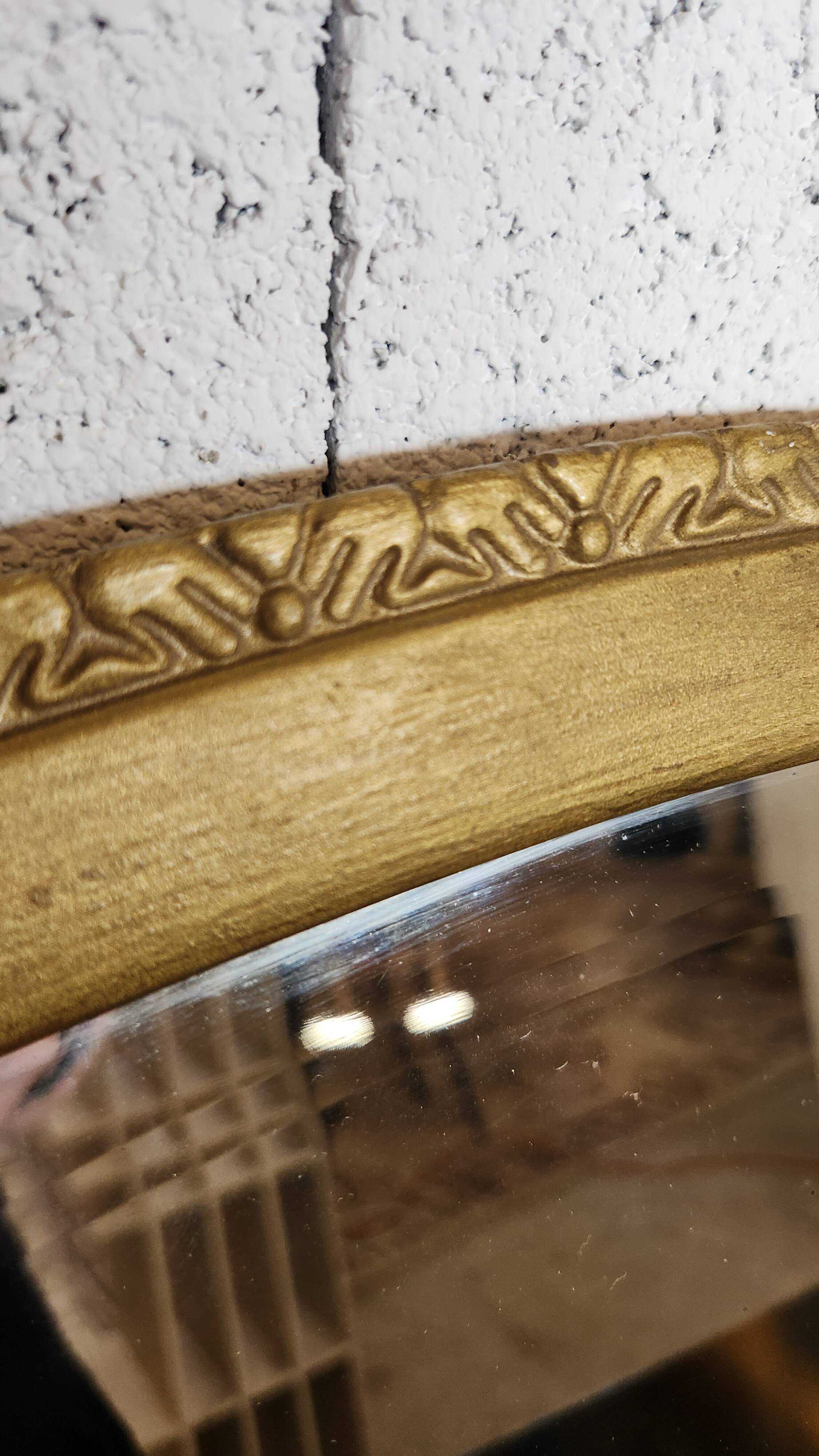 Antique oval mirror with a gilded frame, bevelled glass.