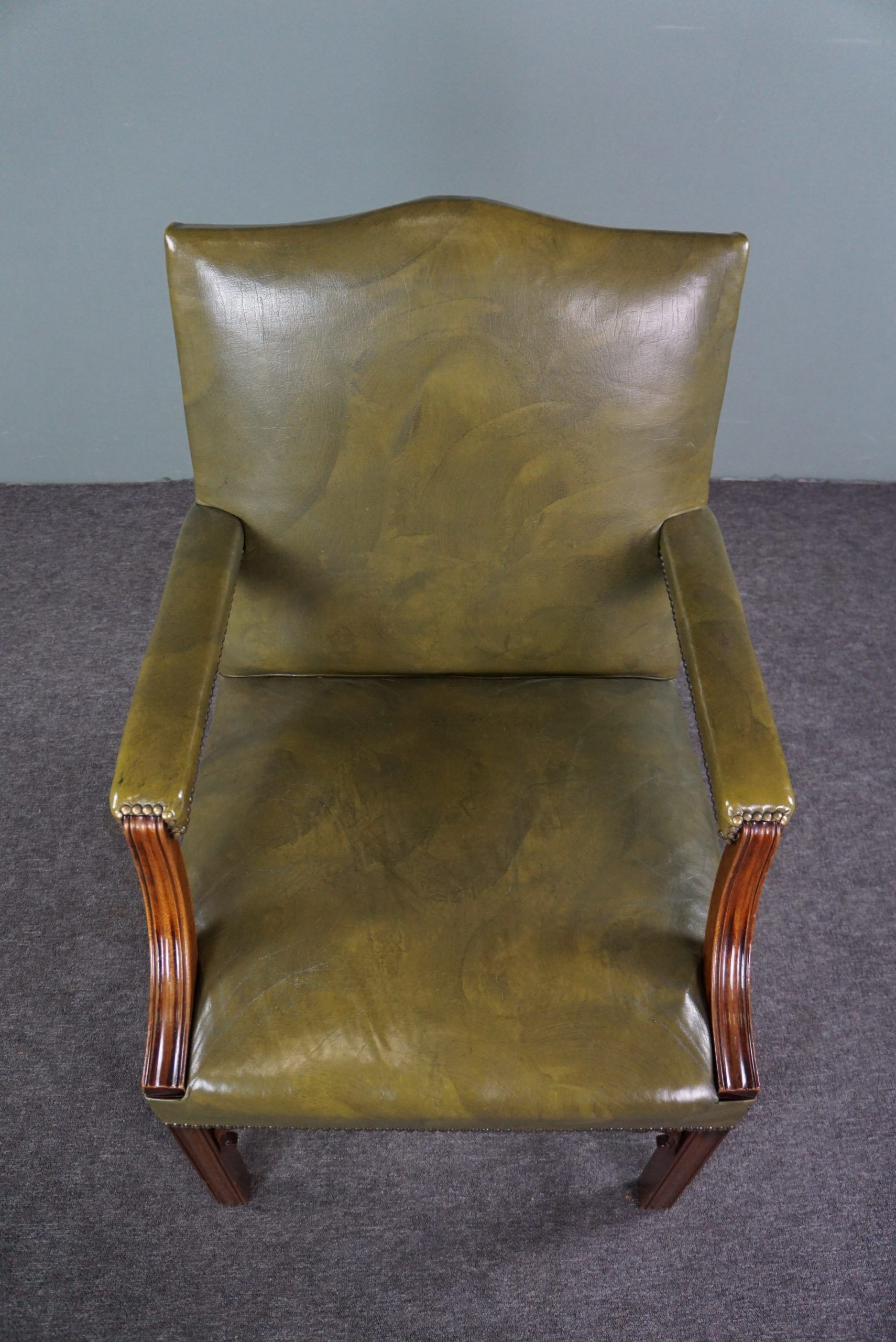 Elegant armchair and footrest in English green leather