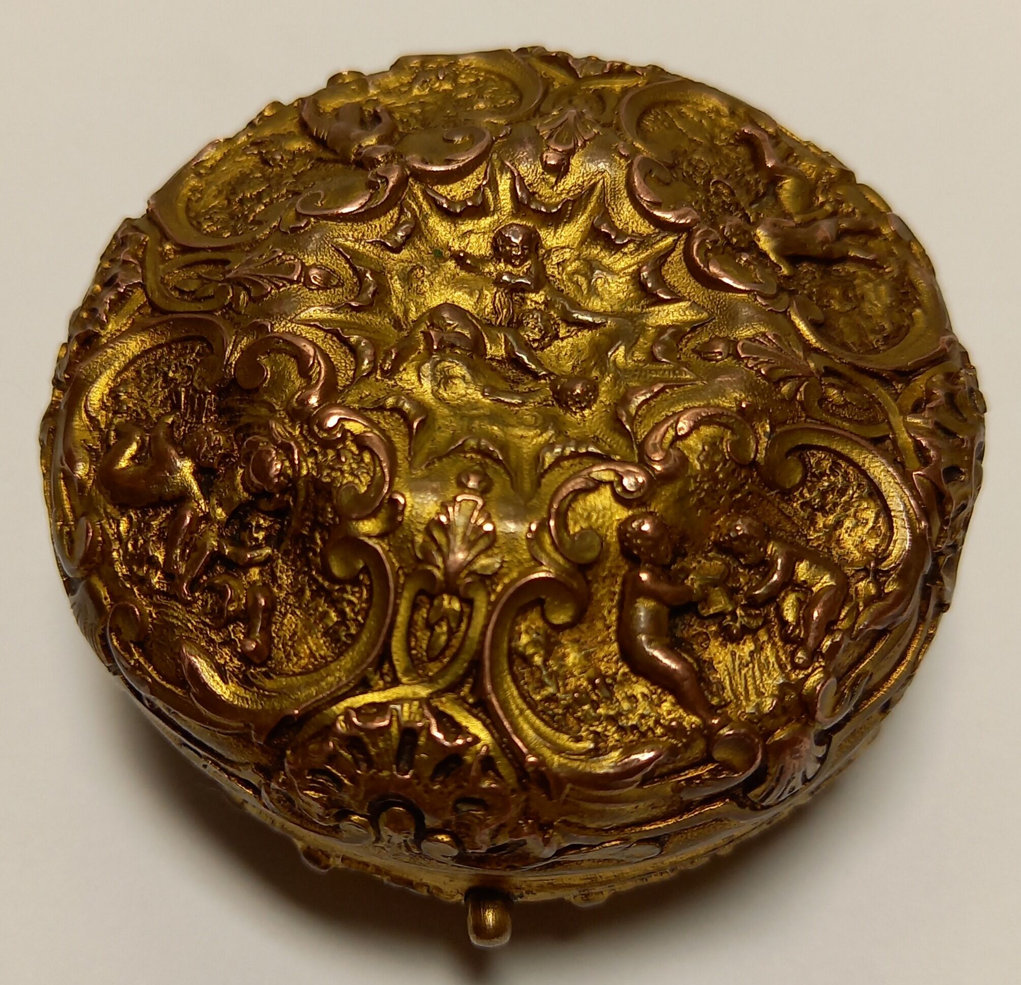 Old brass and copper powder magazine decorated with cherubs