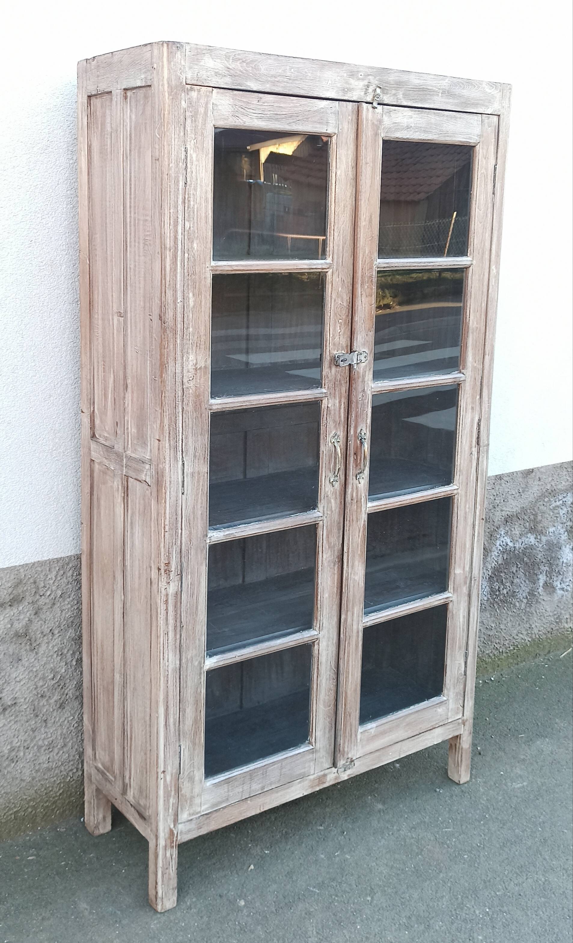 Glass cabinet in old whitewashed wood