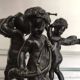 Three musician angels, bronze sculptures on a marble base.