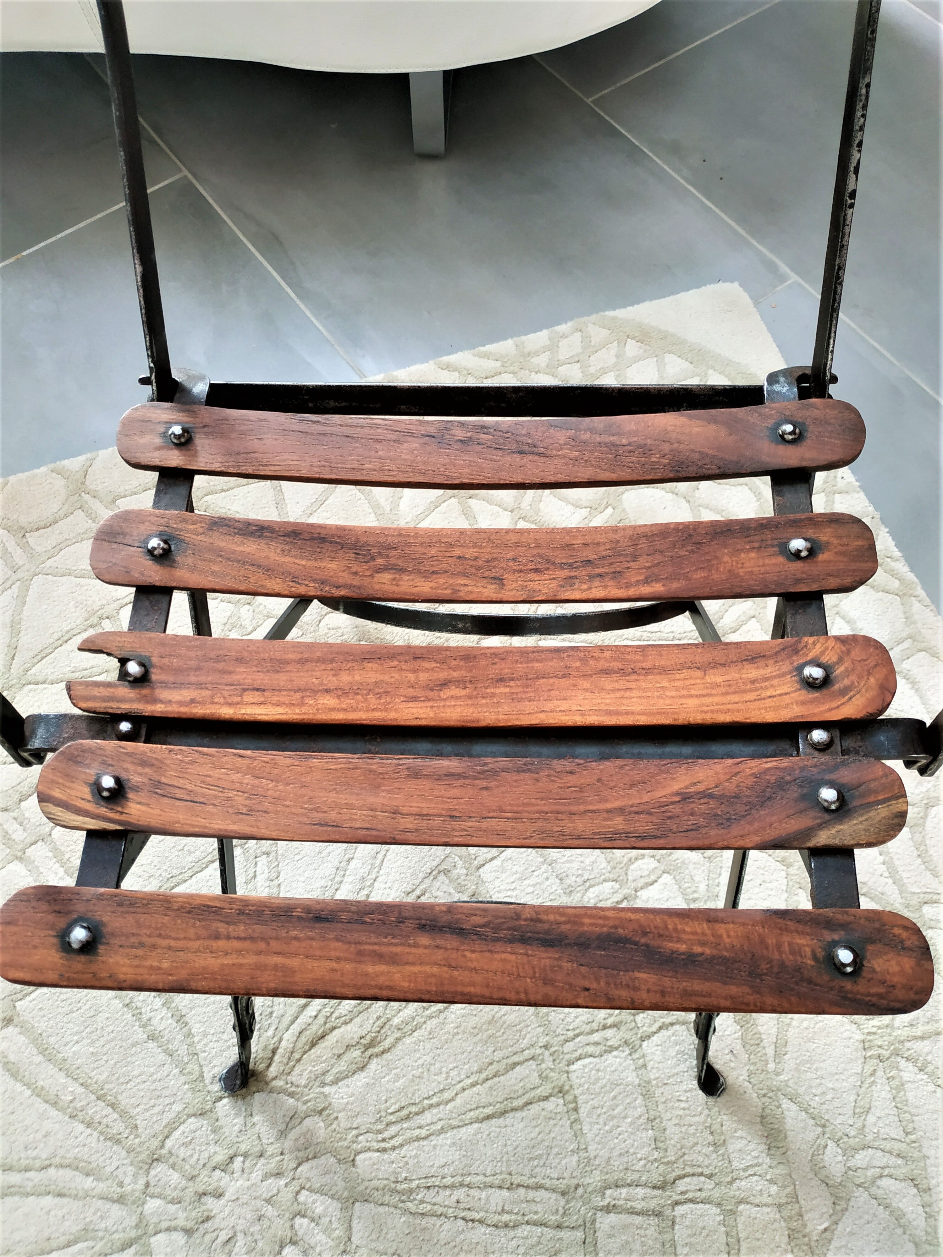 Folding garden chair with teak slats on a wrought iron structure