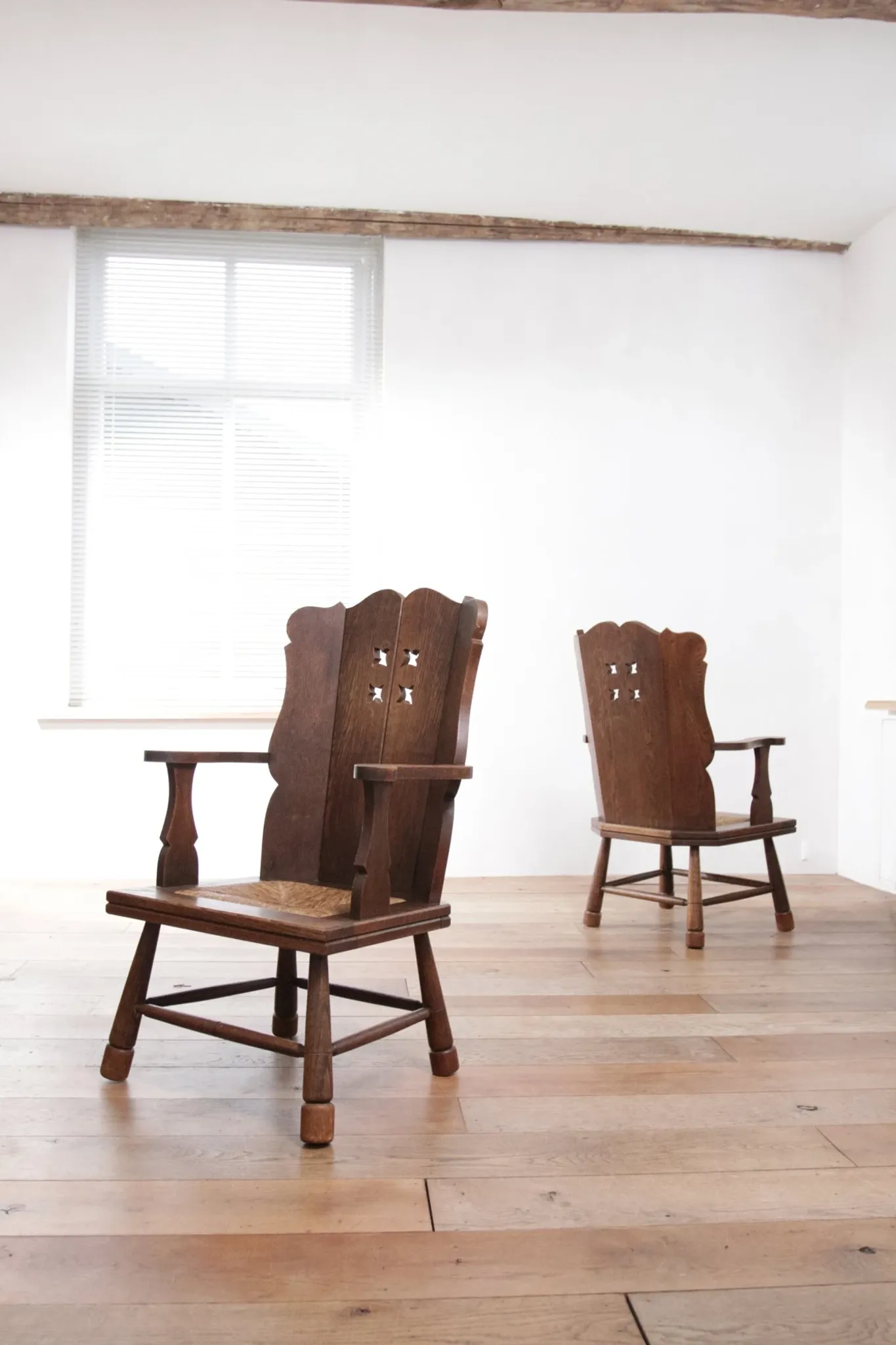 Pair of brutalist oak lounge chairs with rush seats, circa 1935