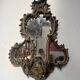 Mirror with a decorative frame featuring a four-light wall sconce, 19th century.