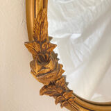 Oval mirror with a gilded frame and carved with bouquets of roses