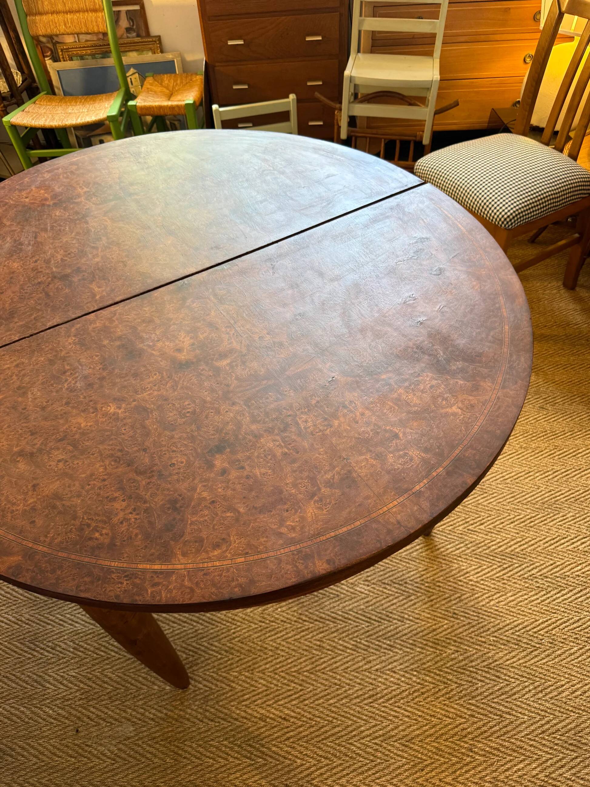 Oval extendable dining table in wood and walnut burl veneer.