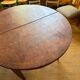 Oval extendable dining table in wood and walnut burl veneer.