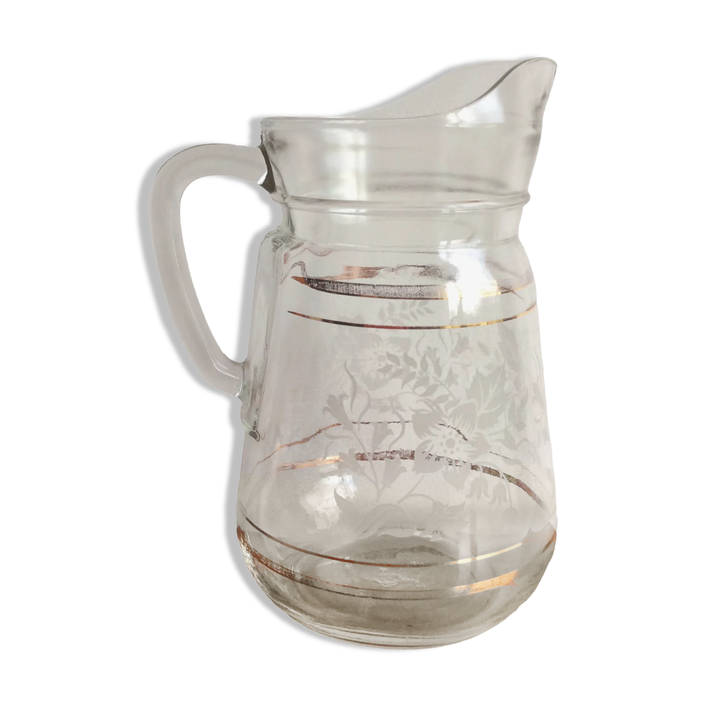 Old glass water pitcher with white flowers in relief with gold edging