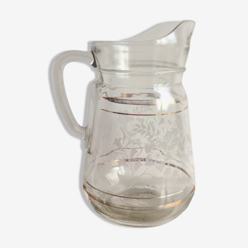 Old glass water pitcher with white flowers in relief with gold edging
