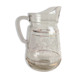 Old glass water pitcher with white flowers in relief with gold edging