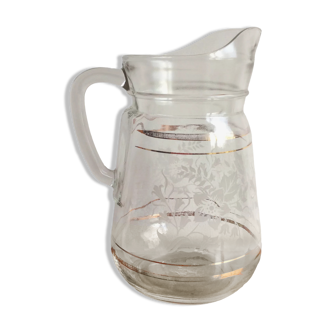 Old glass water pitcher with white flowers in relief with gold edging