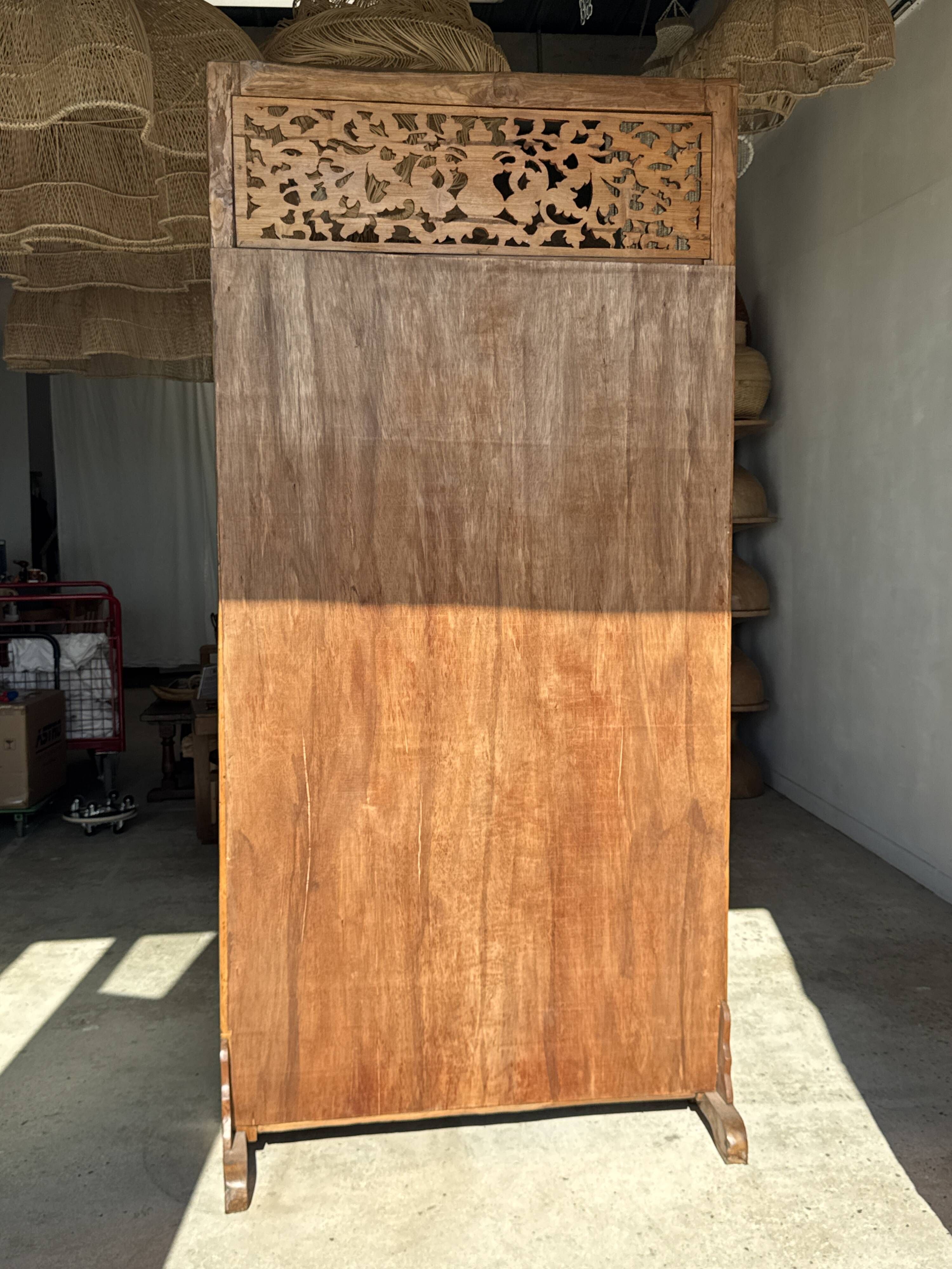 Very large freestanding teak mirror with an openwork carved pediment, Indonesia.