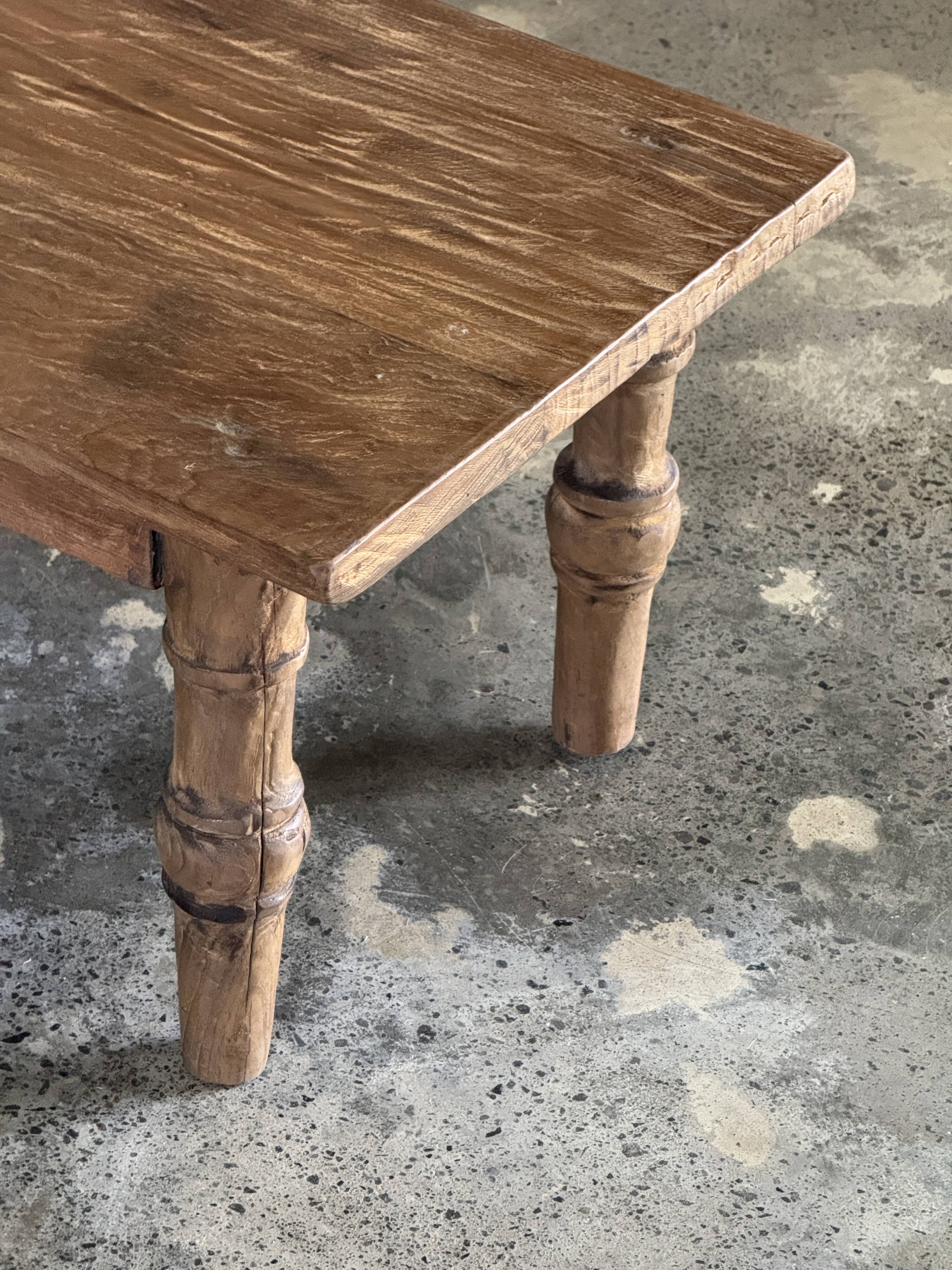 Brown Indonesian teak coffee table, with a border and cylindrical legs H40 L103.