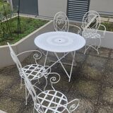 Folding round table and four wrought iron armchairs
