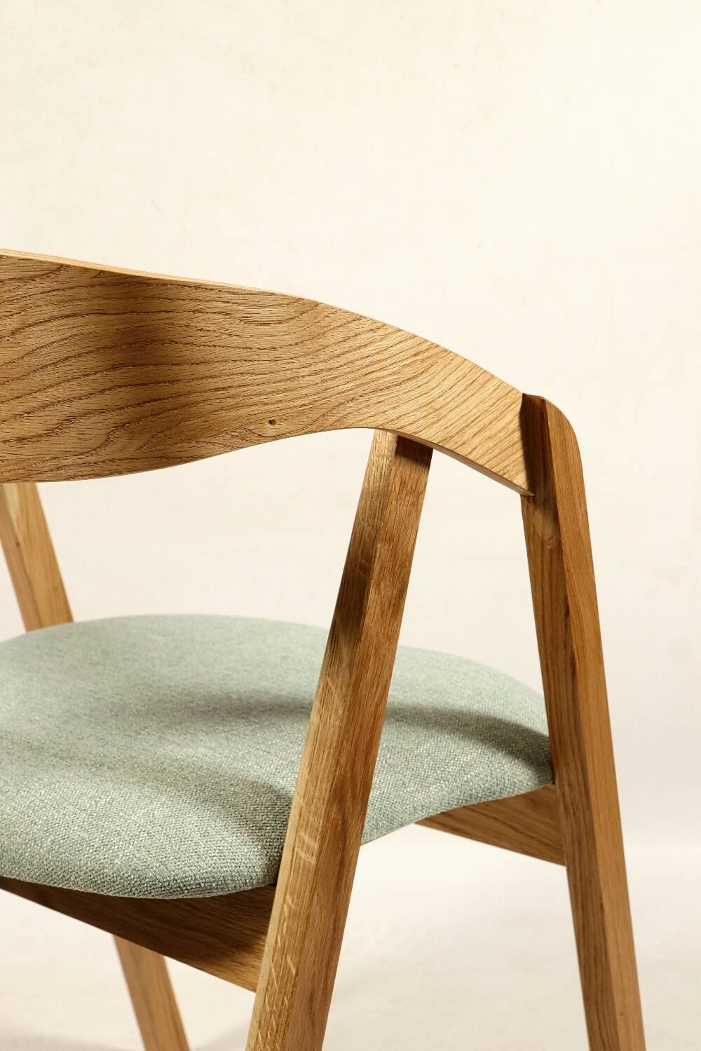 Vintage dining chair in light oak with natural linen pastel green fabric.