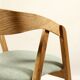 Vintage dining chair in light oak with natural linen pastel green fabric.