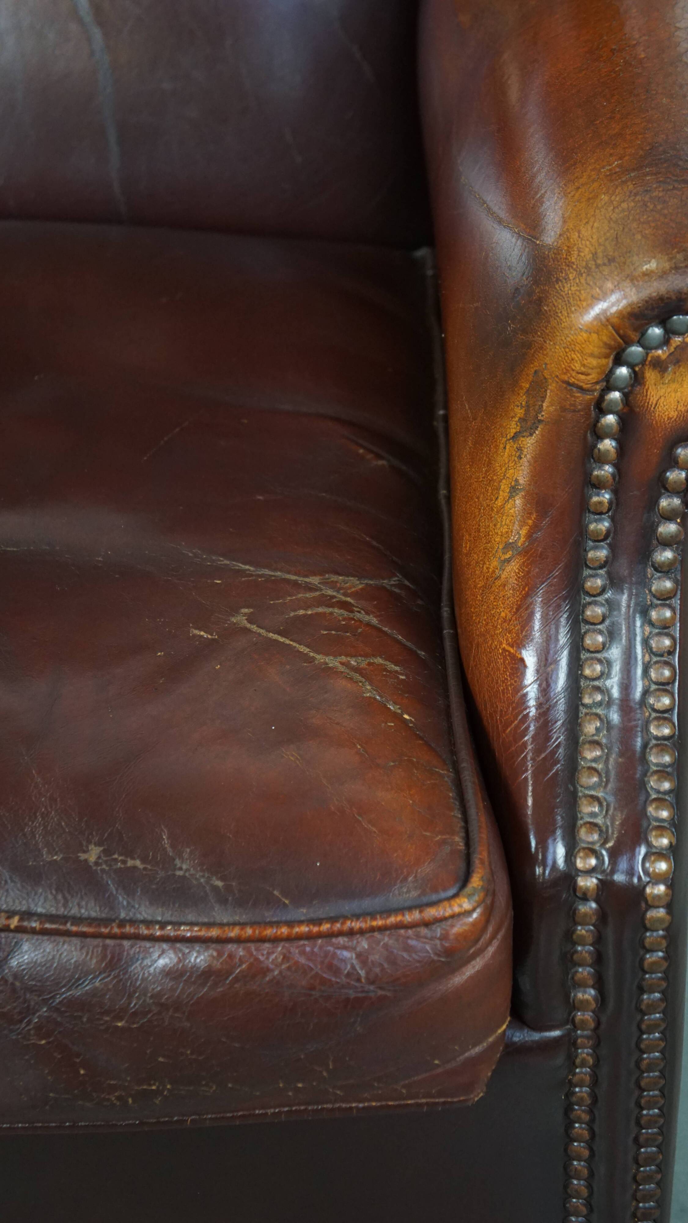 Dark English style sheepskin wingback chair with character and patina