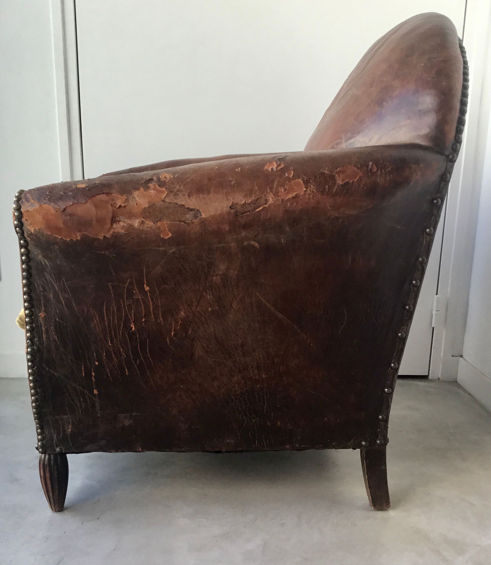 Club armchair in studded leather - early twentieth century