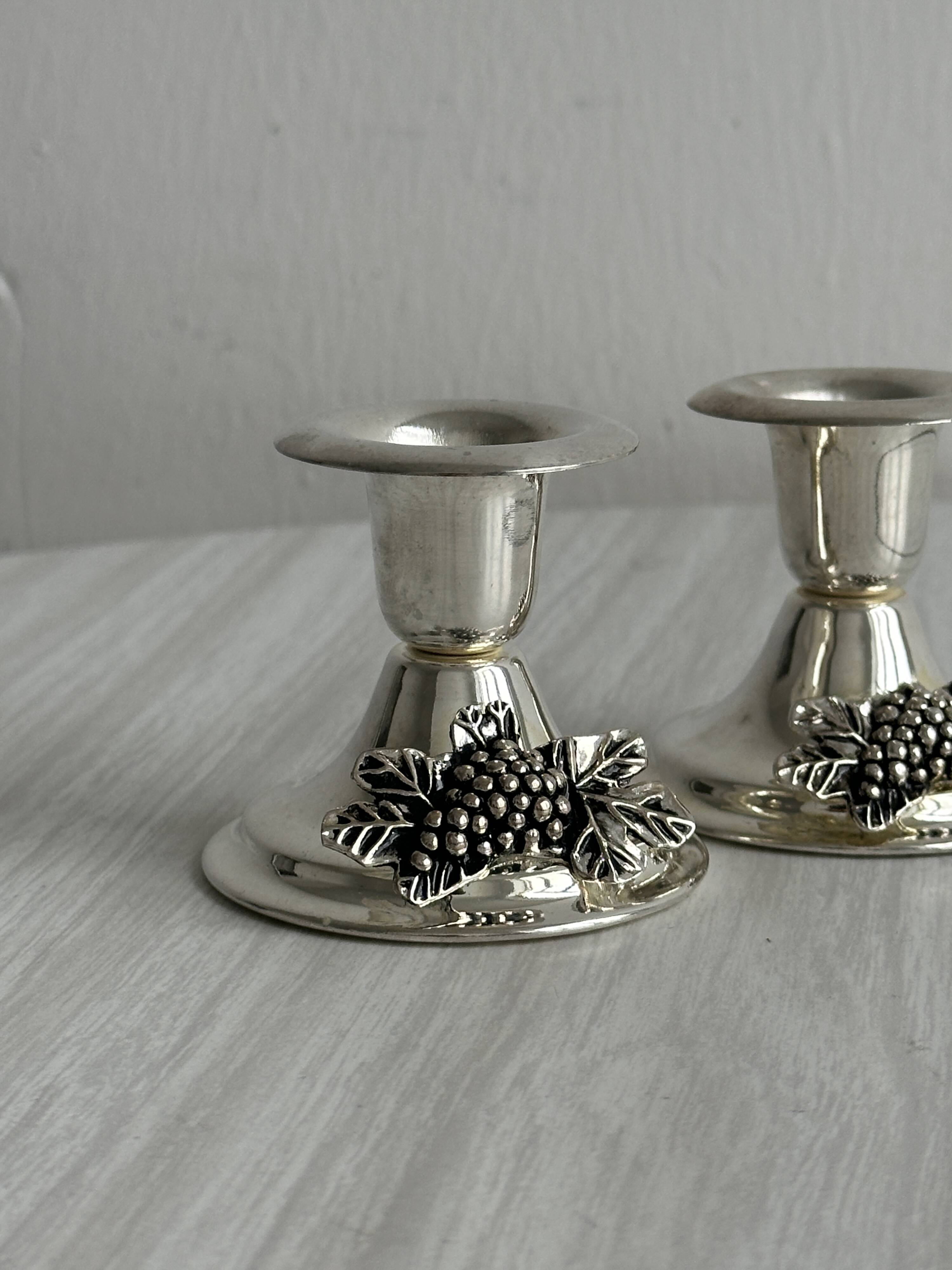Pair of vintage metal candlesticks with a grape pattern.