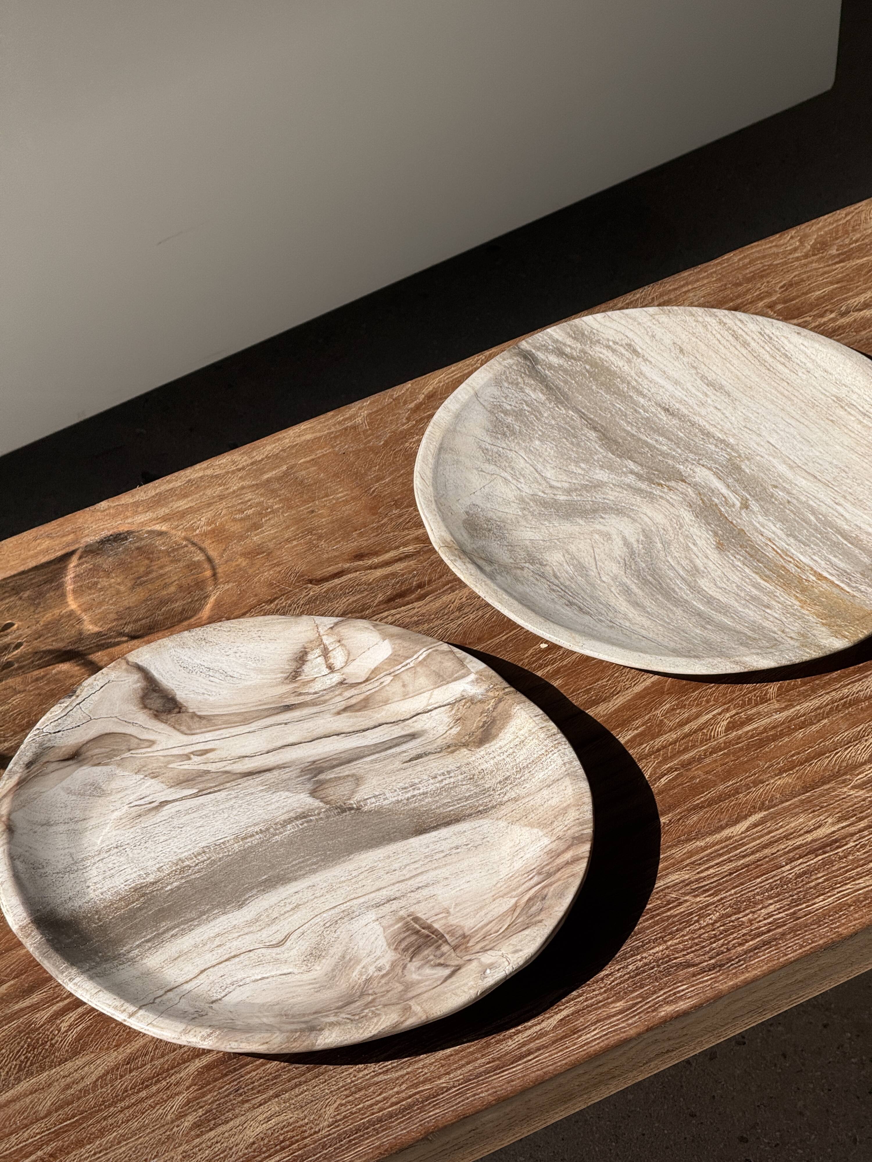 Tray, circular dish or plate made of white striped grey petrified wood.