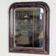 Antique Louis Philippe mirror with a patinated black frame.