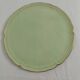 Large pastel green plate with a golden rim.