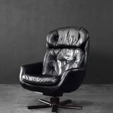 Vintage black leather swivel chair in mid-century modern Scandinavian style.