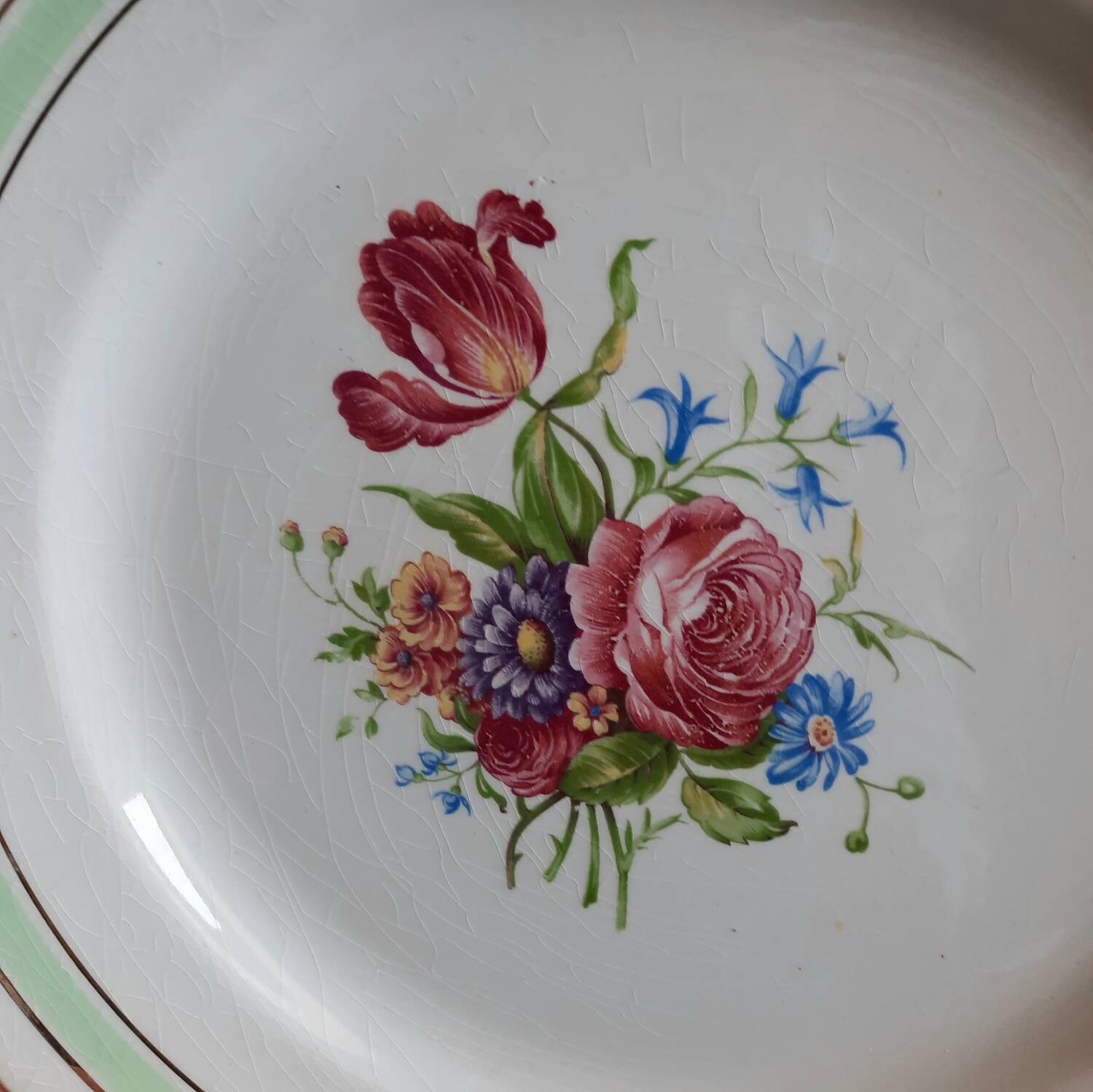 Old mismatched earthenware dinner plates with gold accompanied by a dish