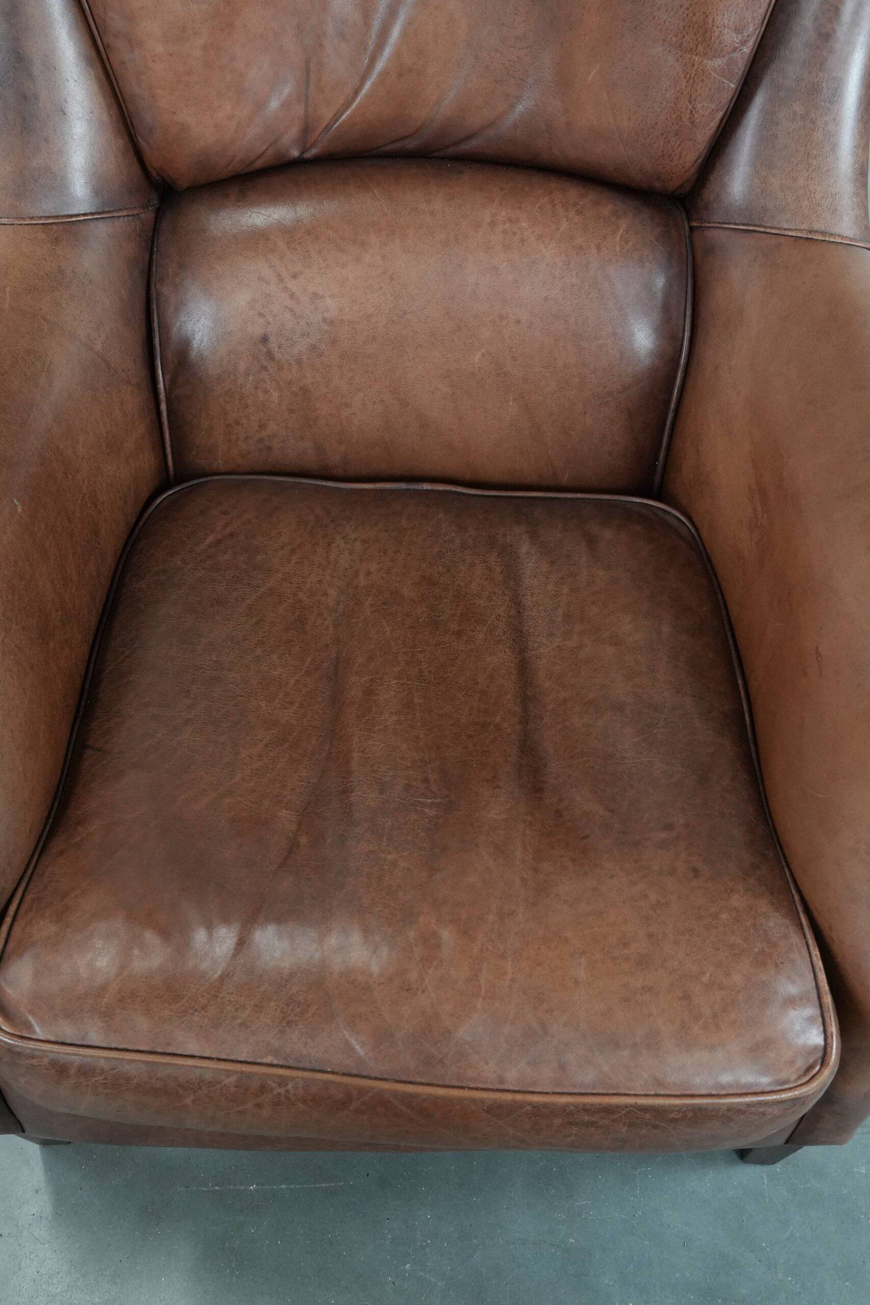 Cognac brown cow leather armchair with decorative nail finish