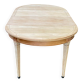 Renovated extendable round table in Directoire style made of light wood with 2 leaves.
