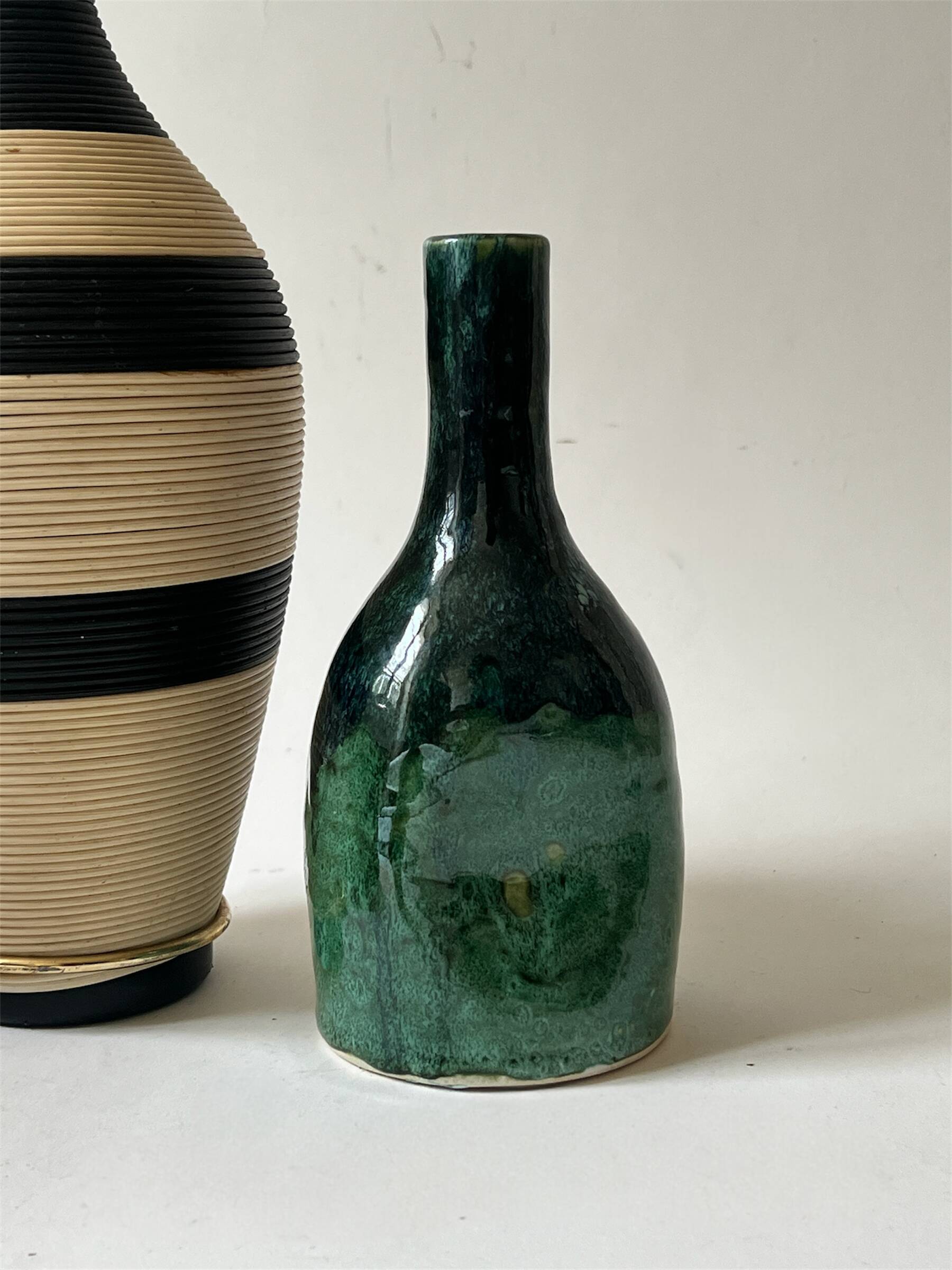 Ceramic vase with a glazed blue/green finish.