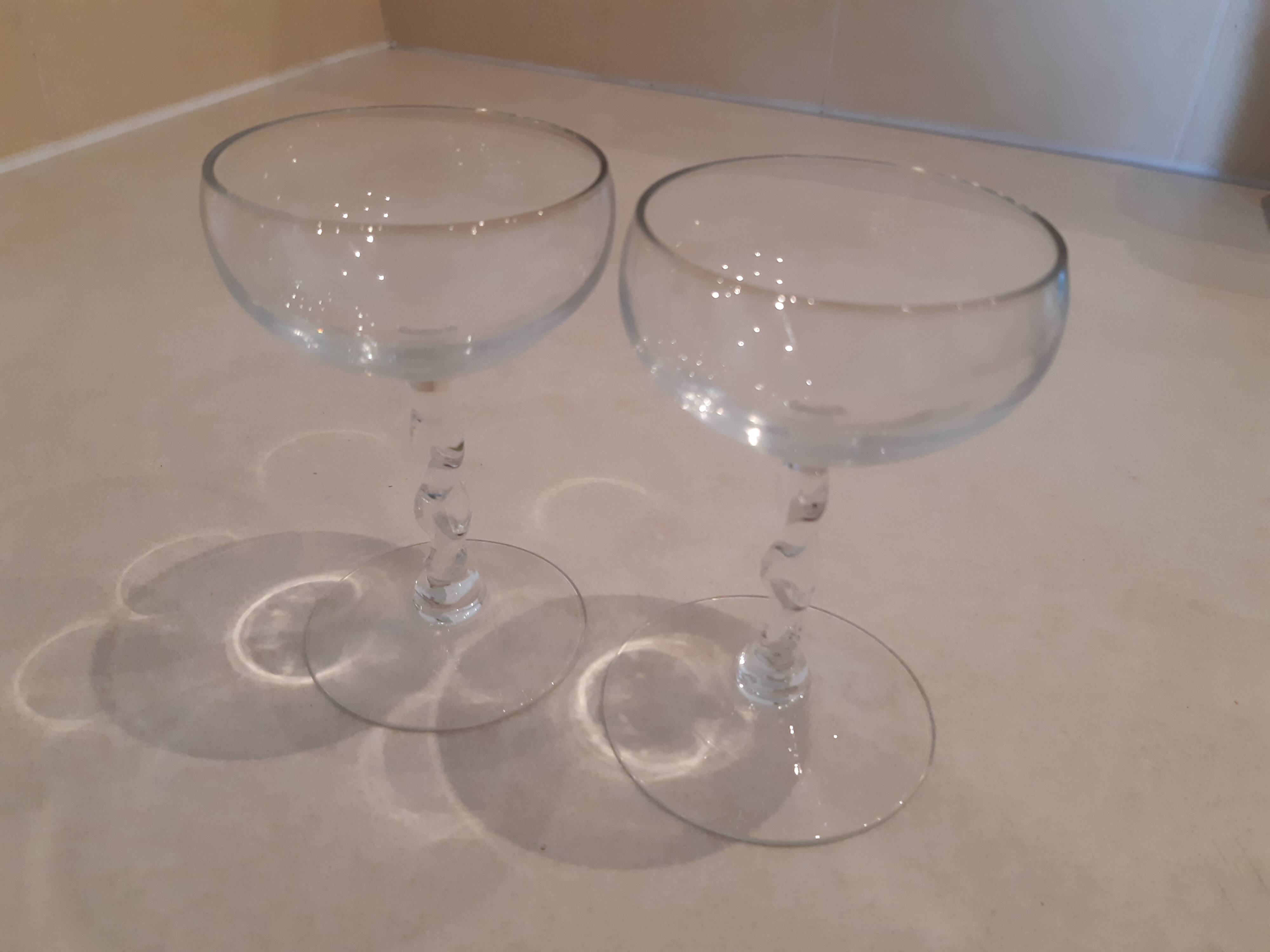 Two small crystal champagne glasses with twisted stems.