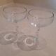 Two small crystal champagne glasses with twisted stems.