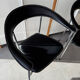 Set of two metal chairs with a brushed finish and black leather.