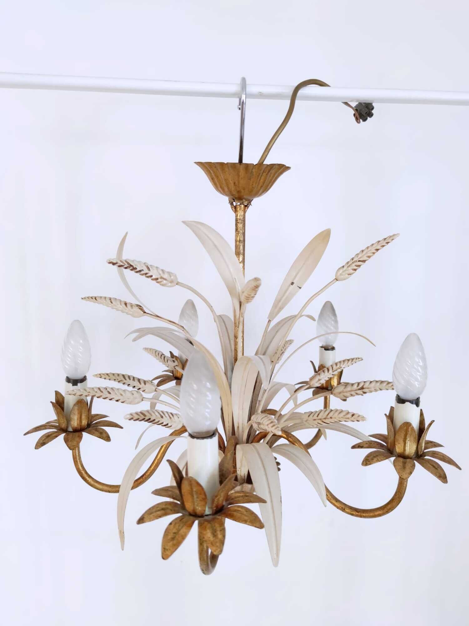 Vintage wrought iron chandelier decorated with golden and beige reeds