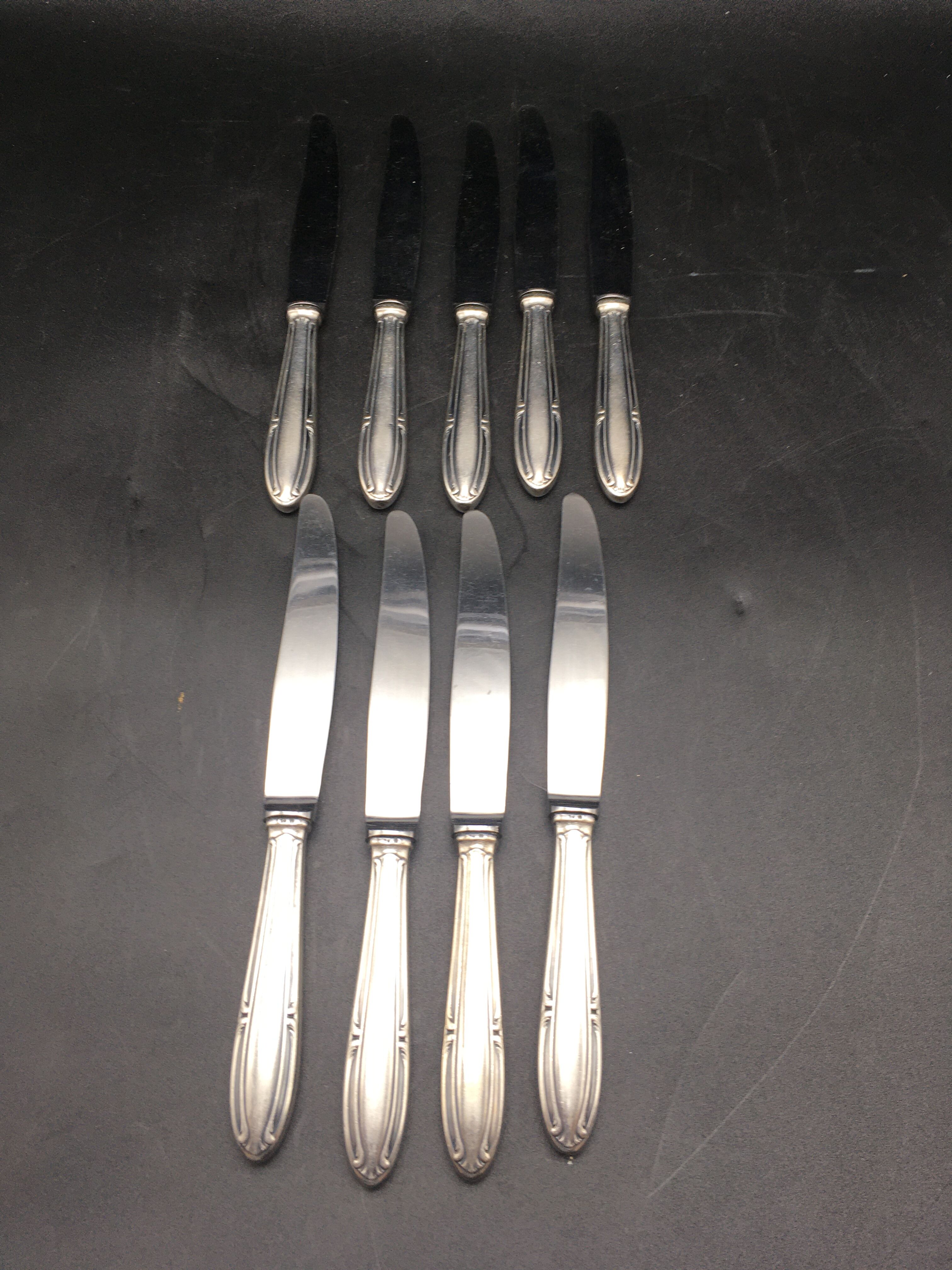 9 table knives in silver metal.