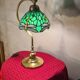 brass lamp with green stained glass shade.