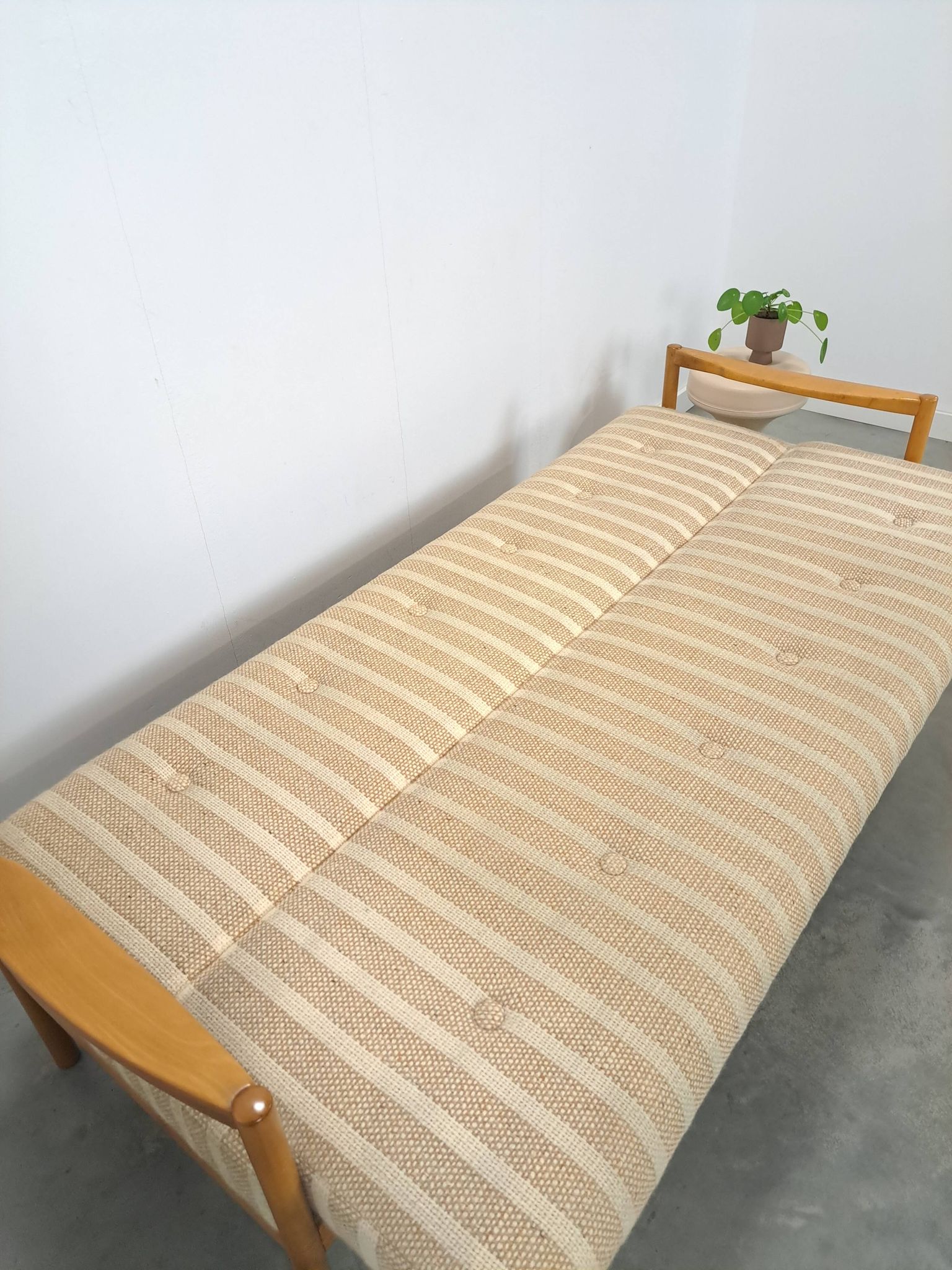 Canapé-lit beige rayé avec cadre en bois