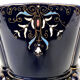 Large earthenware pot cover with enamelled decoration on a blue oven background