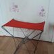 Folding stool in red canvas but unstitched on one side