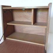 Vintage 1960s secretary desk with an angled design, light wood, and tapered legs.