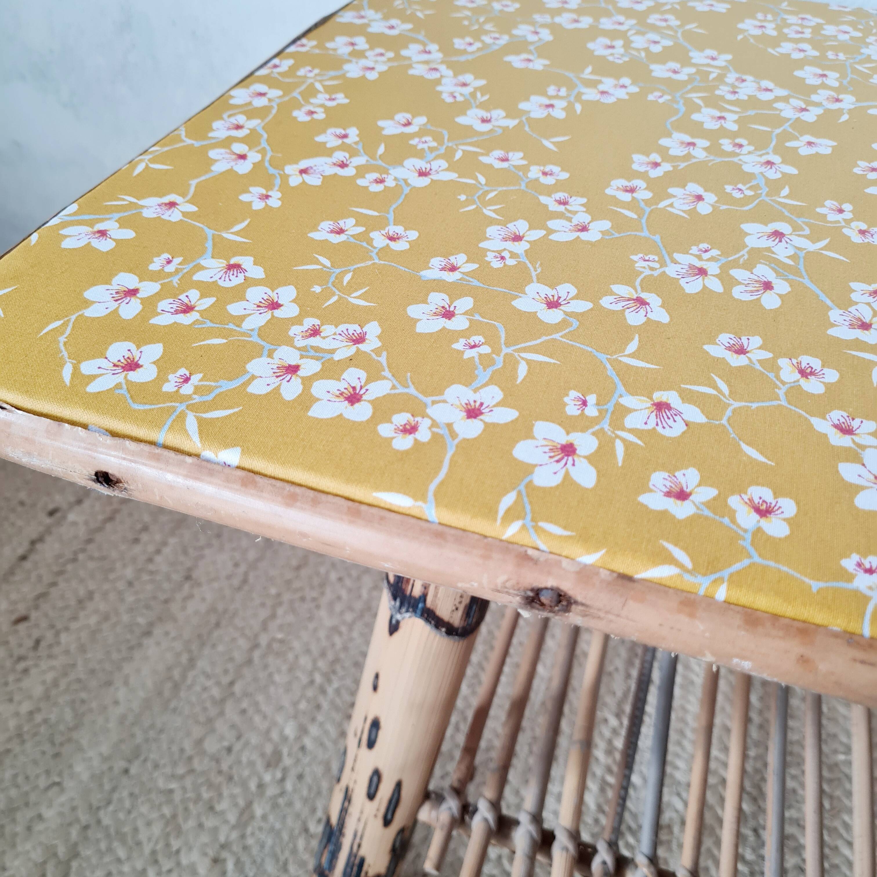 Table basse en rotin plateau tissu fleuri jaune
