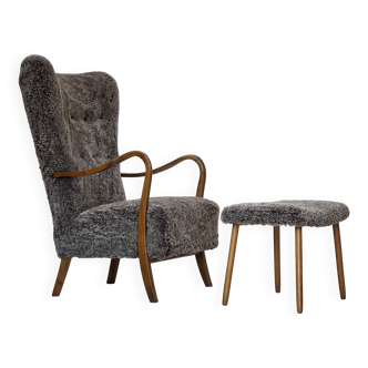 Fauteuil danois retapissé des années 1960, avec tabouret, en peau de mouton véritable.