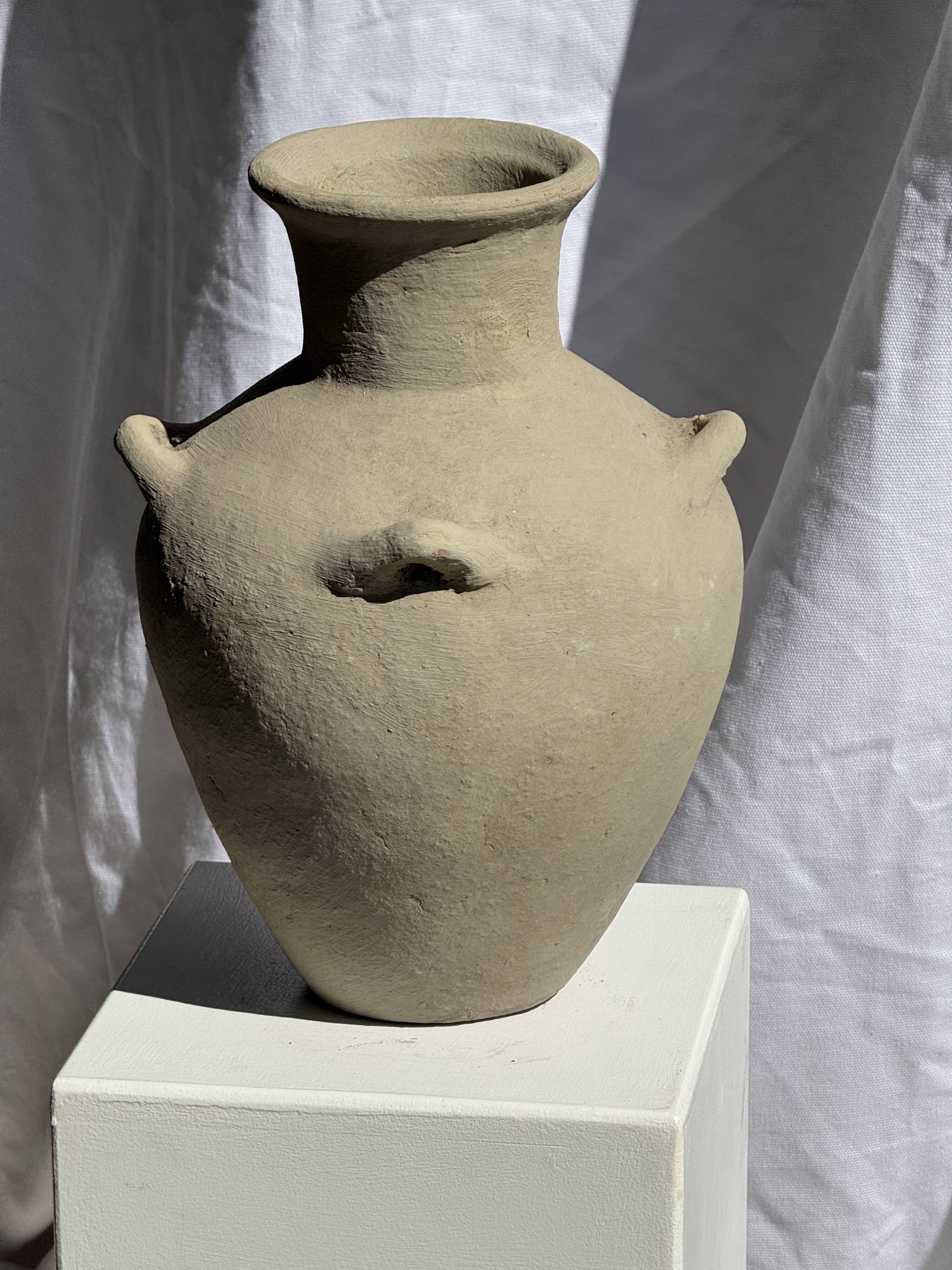 Light beige-grey Indonesian terracotta vase with 4 small handles and a high neck.