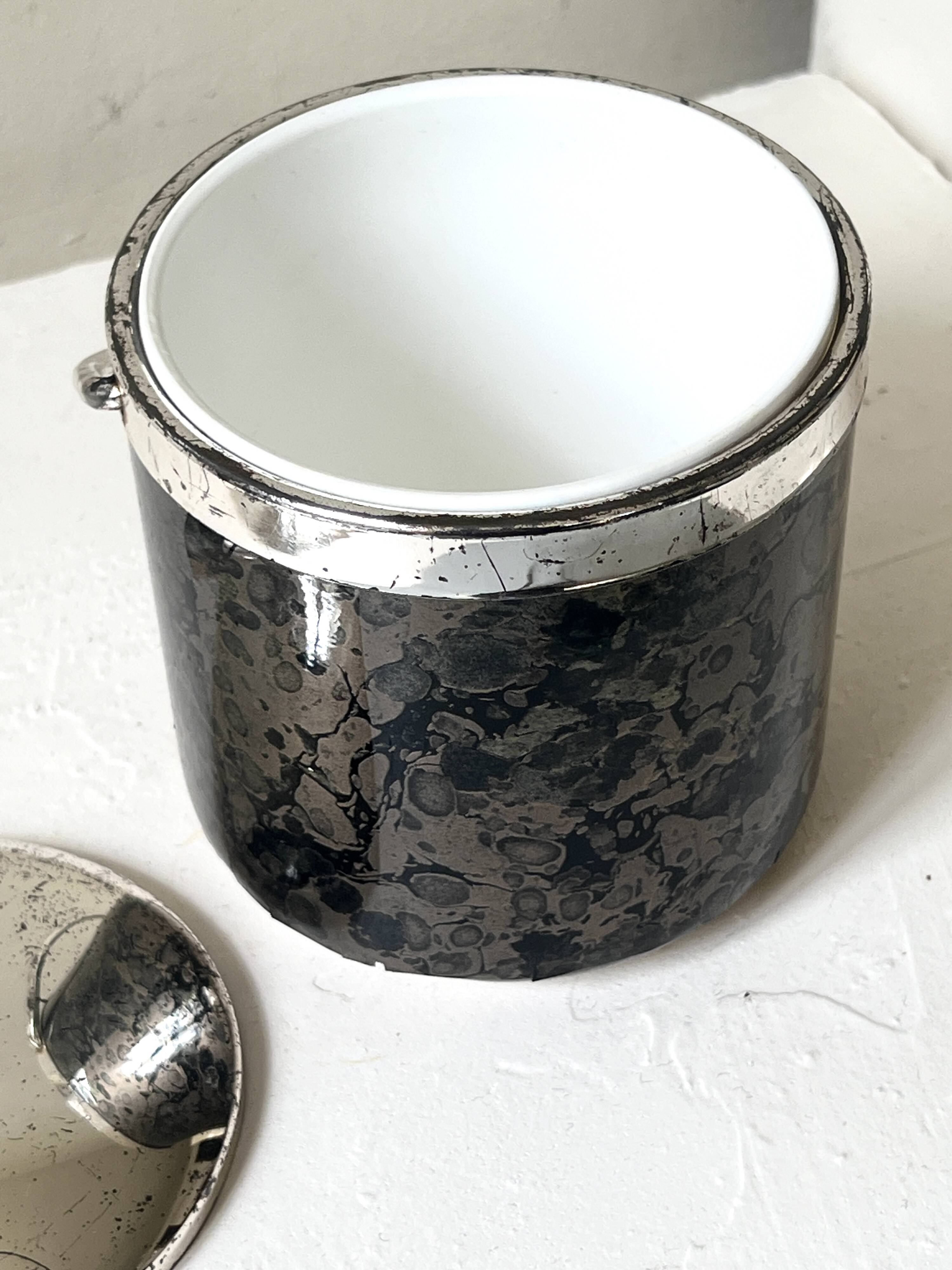 Vintage chrome metal ice bucket with black marbled design, 1970s style.