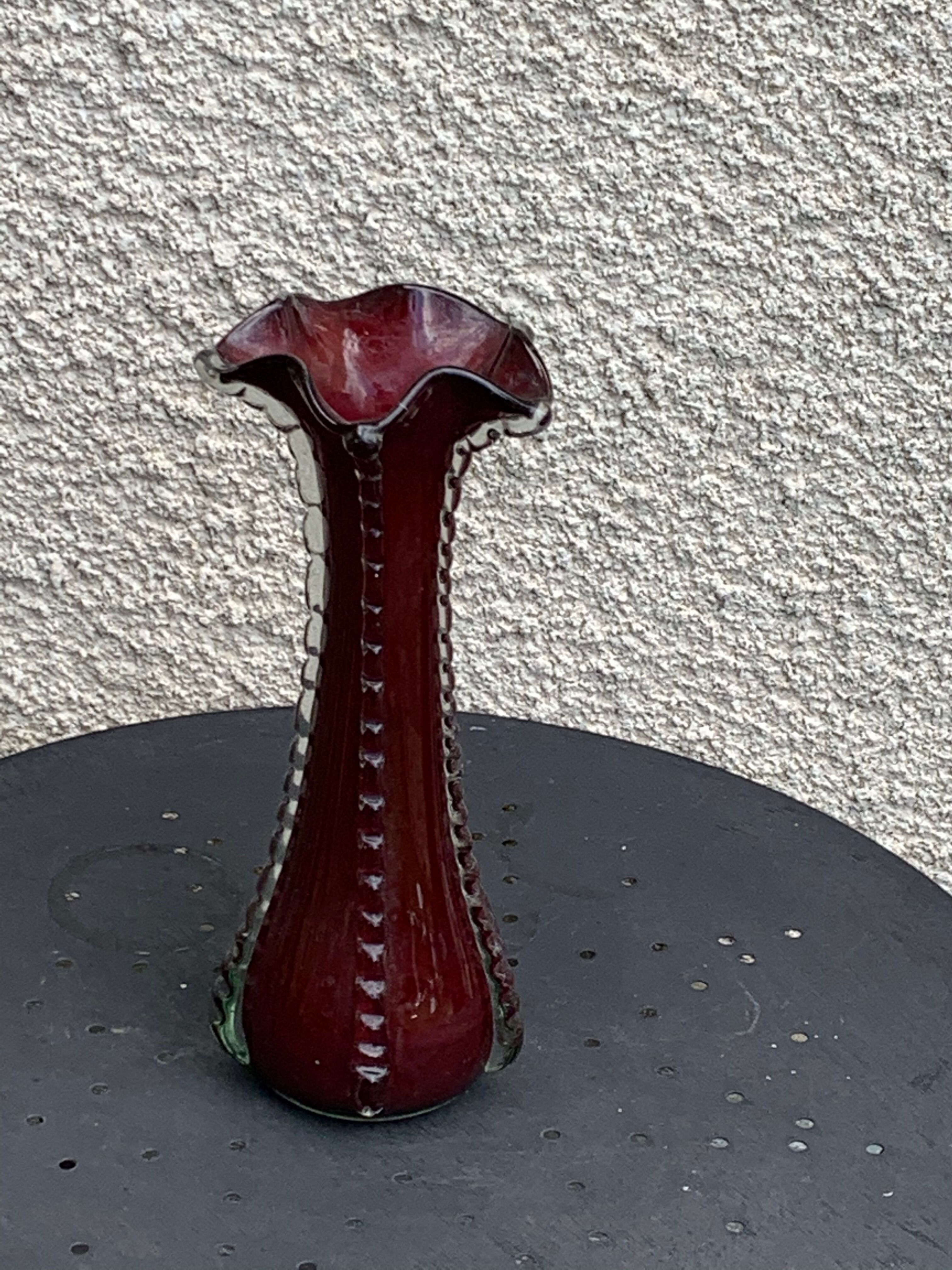 Burgundy red blown glass vase in the shape of a vintage corolla